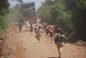 The caravan heads for an outlying suburb of Eldoret, chased by children