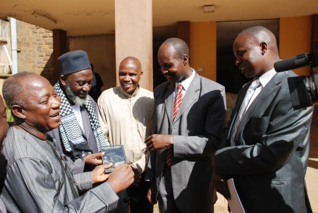 District Commissioner of Eldoret Christopher Wanjau and County Secretary Phillip Arap Meli receive DVD copies of 'An African Answer' from Pastor James Wuye and Imam Muhammad Ashafa. Joseph Wainaina is third from left.