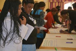 Denise from South Africa and Angie from Zimbabwe study some documentation