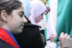 Students writing on the Nigerian flag (Photo:  Adyan)